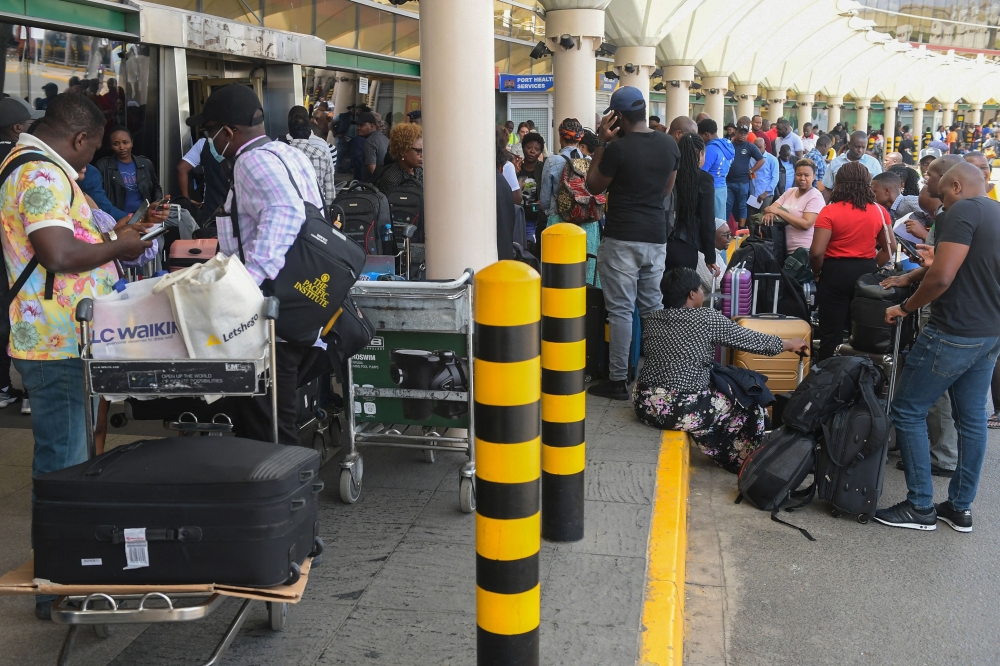 Passengers wait in a queue at the Jomo Kenyatta International airport, to re-book their flights after flights were cancelled, amid a strike by pilots organised by Kenya Airline Pilots Association (KALPA), at the Jomo Kenyatta International airport in Nairobi on November 5, 2022. (AFP/Simon Maina)