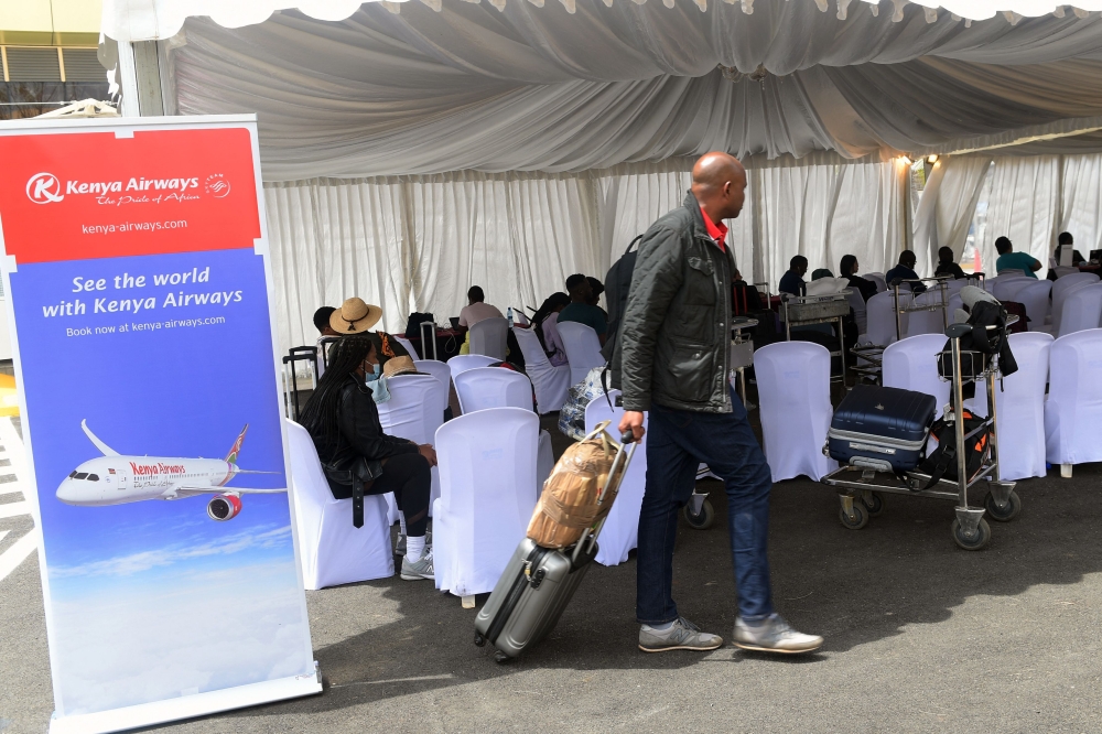 A passenger approaches a Kenya Airways help desk that assists travelling passengers to re-book flights and hotels, on the second day of a strike by pilots organised by Kenya Airline Pilots Association, at the Jomo Kenyatta International airport in Nairobi on November 6, 2022. (AFP/ Simon Maina)