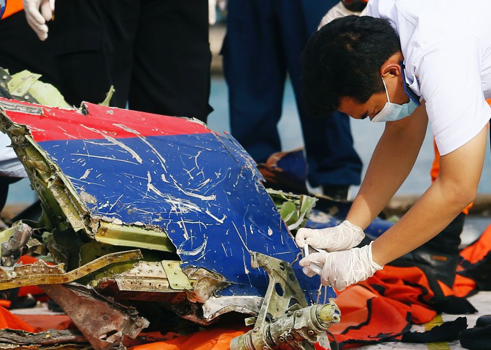 An officer of Indonesia's National Transportation Safety Committee takes pictures of the remains of Sriwijaya Air flight SJ 182, which crashed into the Java Sea, on the last day of its search and rescue operation, at Tanjung Priok port in Jakarta, Indonesia, January 21, 2021. REUTERS/Ajeng Dinar Ulfiana