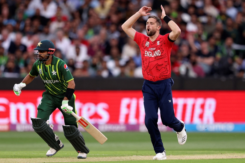 England's Chris Woakes reacts as Pakistan's Captain Babar Azam (L) runs between the wickets during the ICC men's Twenty20 World Cup 2022 cricket final match between England and Pakistan at the Melbourne Cricket Ground (MCG) on November 13, 2022 in Melbourne. Photo by Martin Keep/ AFP