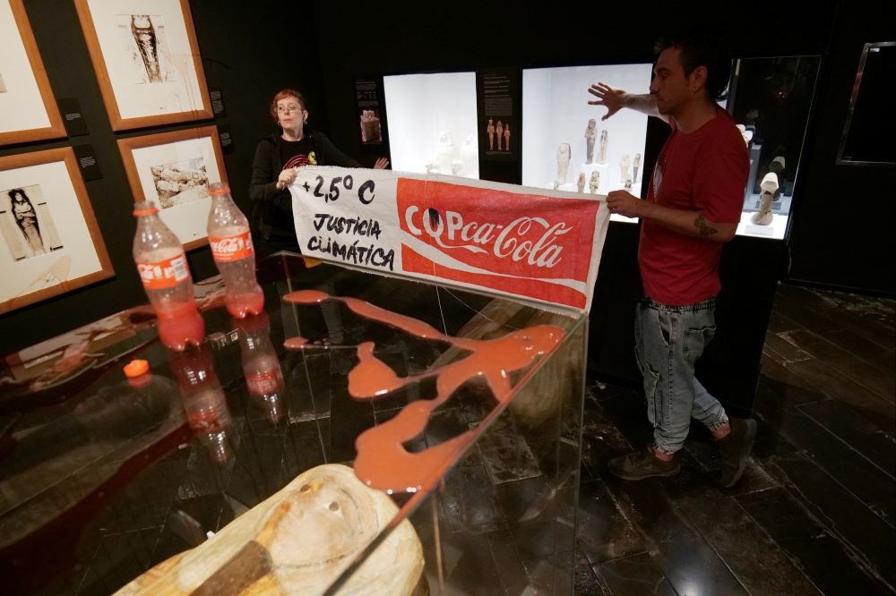 Climate activists of 'Futuro Vegetal' pose after throwing syrup and beetroot juice to resemble petrol and blood at the Egyptian Museum in Barcelona, Spain, November 13, 2022. (Futuro Vegetal via REUTERS)