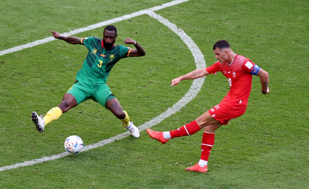 Switzerland's Granit Xhaka in action with Cameroon's Nicolas Nkoulou during the Qatar 2022 World Cup Group G football match between Switzerland and Cameroon at the Al-Janoub Stadium in Al-Wakrah, south of Doha on November 24, 2022. (Photo by Glyn KIRK / AFP) 
