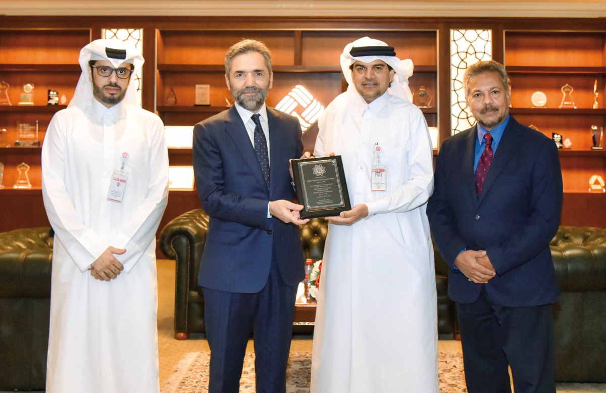 QIIB CEO Dr. Abdulbasit Ahmed Al Shaibei, receiving a commemorative shield from Prof. Dr. Recep Şentürk, Dean of the College of Islamic Studies at HBKU in the presence of Dr. Syed Nazim Ali, Director of the Center for Islamic Economics and Finance at HBKU and Omar Abdulaziz Al Meer, Head of Business Development and Alternative Channels Sector at QIIB.
