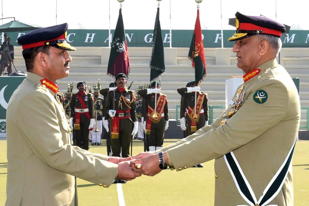 In this handout photograph taken and released by Pakistan's Inter Services Public Relations (ISPR) on November 29, 2022, Pakistan's new Army Chief General Syed Asim Munir (left) receives the change of command baton from outgoing army chief General Qamar Javed Bajwa (right) during the change of command ceremony in Rawalpindi. (Photo by Pakistan's Inter Services Public Relations (ISPR) / AFP)