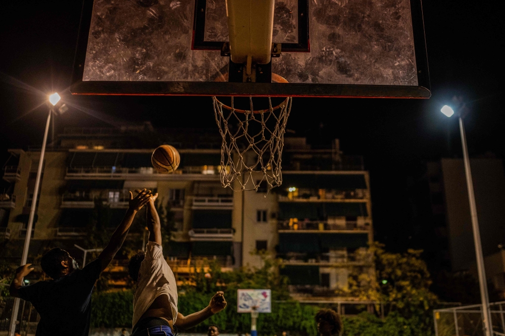 Children who are second-generation migrants play basketball at a basketball court in the centre of Athens on October 8, 2022. Photo by Angelos Tzortzinis / AFP
