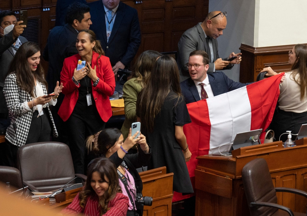 Peruvian congress members react after the vote for the impeachment of President Pedro Castillo in Lima on December 7, 2022.  (Photo by Cris BOURONCLE / AFP)