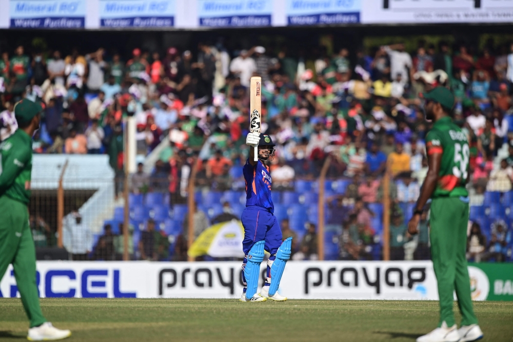 India's Ishan Kishan (C) gestures as he scores a century (100 runs). (Photo by Munir Uz Zaman / AFP)