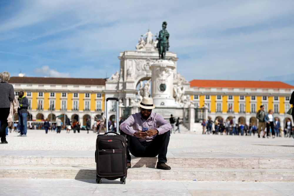 A tourist rests at Comercio square in downtown Lisbon, Portugal, April 11, 2019. (REUTERS/Rafael Marchante)