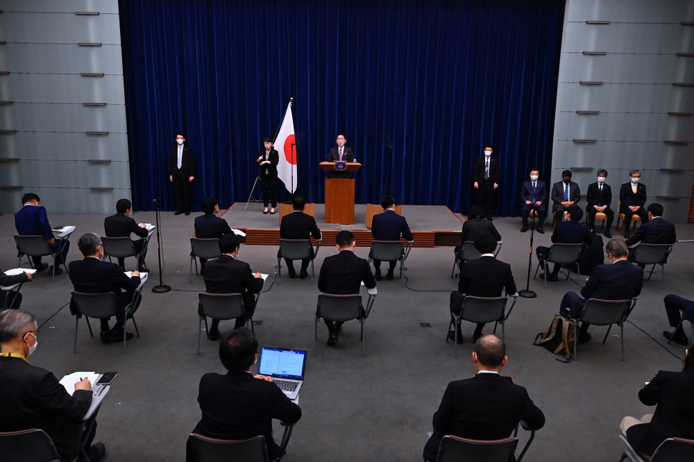 Japan's Prime Minister Fumio Kishida (centre) attends a press conference in Tokyo on December 16, 2022. (Photo by David Mareuil / AFP)