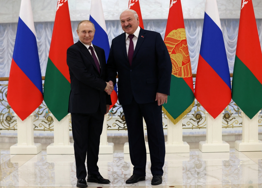 Russian President Vladimir Putin and Belarusian President Alexander Lukashenko shake hands before their meeting at the Palace of Independence in Minsk, Belarus on December 19, 2022. Sputnik/Konstantin Zavrazhin/Pool via REUTERS 