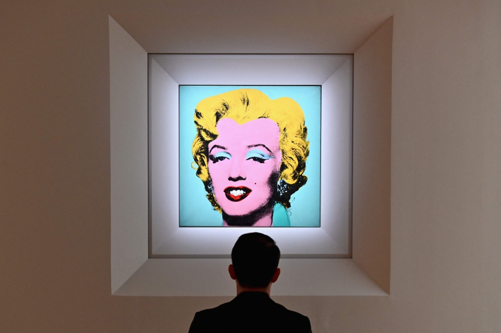 In this file photo taken on April 29, 2022 a man looks at Andy Warhol's 'Shot Sage Blue Marilyn' during Christie's 20th and 21st Century Art press preview at Christie's New York in New York City. (Photo by Angela Weiss / AFP)