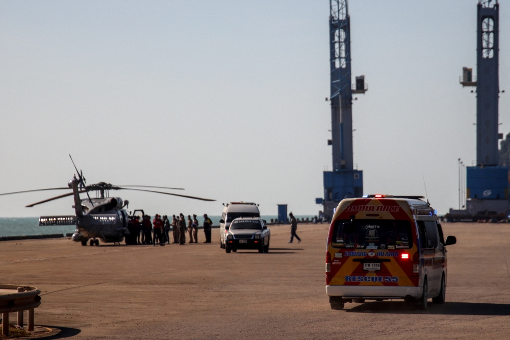 A helicopter carries an injured sailor and a body of a Royal Thai Navy sailor during a rescue mission after a Navy corvette sank in the Gulf of Thailand, in Prachuap Khiri Khan province, December 21, 2022. REUTERS/Napat Wesshasartar