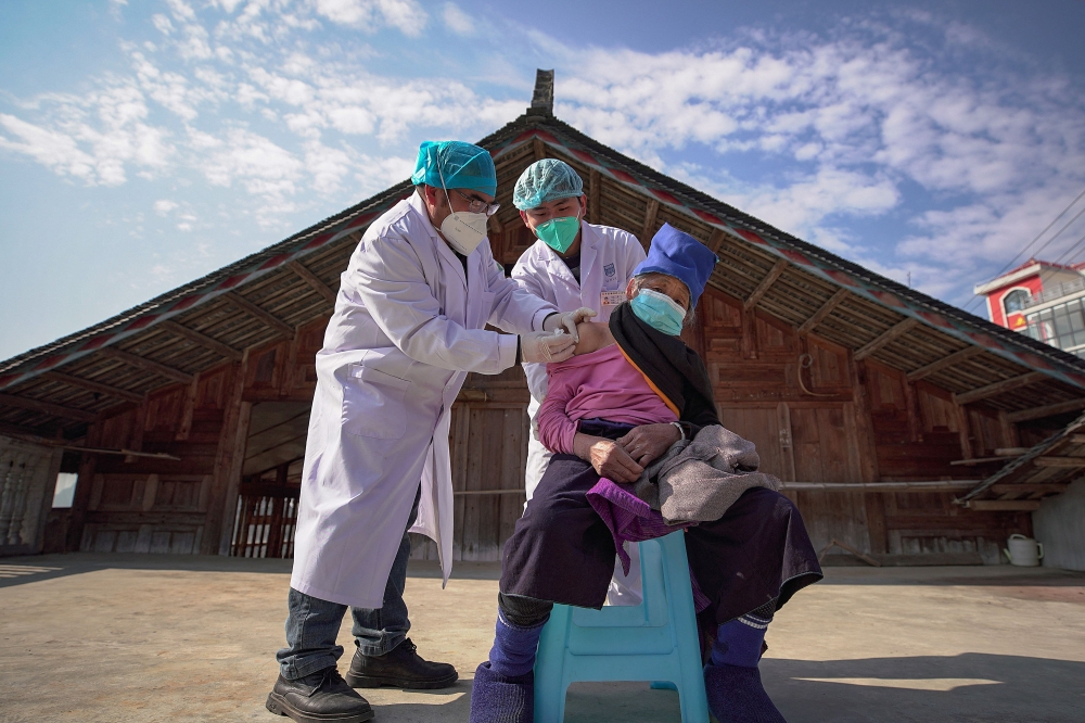 An elderly woman receives a Covid-19 vaccine in Danzhai, in China's southwestern Guizhou province province on December 21, 2022. (AFP) 

