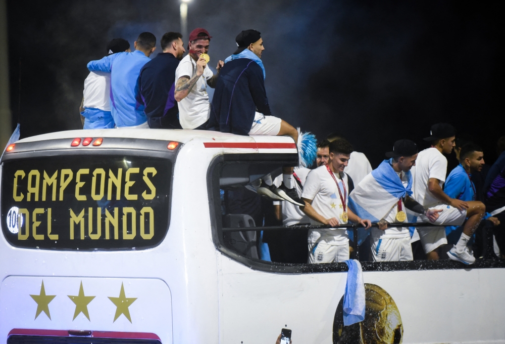 Argentina's Rodrigo De Paul, Leandro Paredes, Lionel Messi and Julian Alvarez are seen on the open top bus as it arrives outside the Association of Argentinian Football Headquarters in Buenos Aires, Argentina, on December 20, 2022. (REUTERS/Mariana Nedelcu)