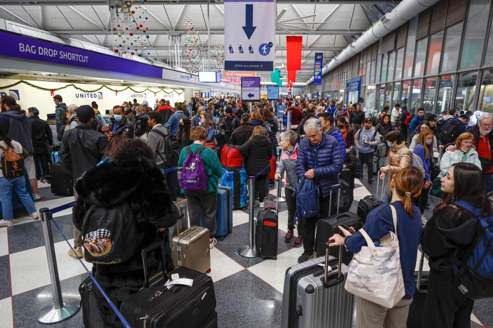 Travelers arrive for their flights at the United Airlines Terminal 1 ahead of the Christmas Holiday, at O'Hare International Airport on December 22, 2022, in Chicago. (Photo by Kamil Krzaczynski / AFP)