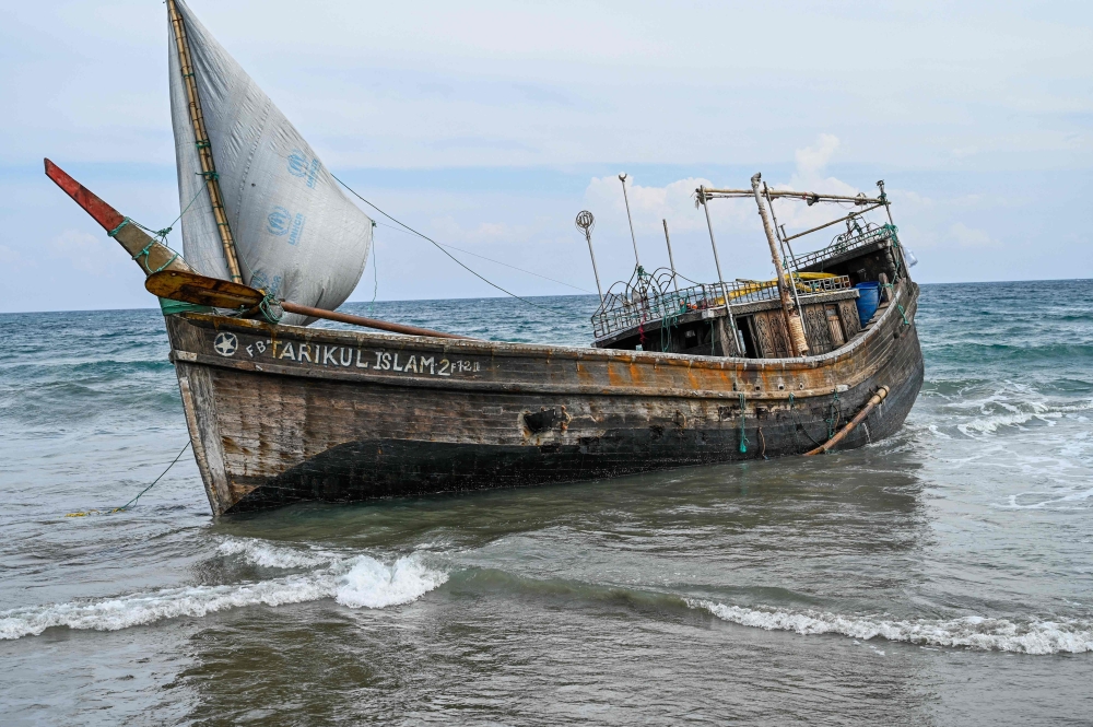 This picture shows a boat that was carrying Rohingya refugees after their arrival at a beach in Krueng Raya, Indonesia's Aceh province on December 25, 2022. Photo by CHAIDEER MAHYUDDIN / AFP