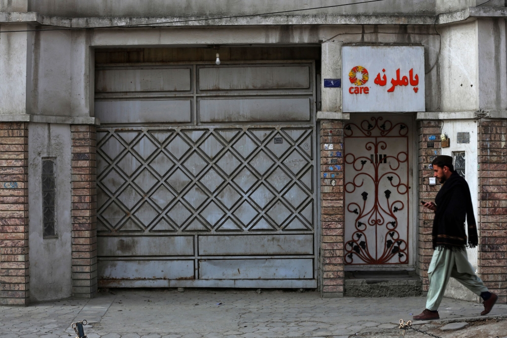 An Afghan man walks past the office of a foreign aid group 'Care' in downtown Kabul on December 26, 2022. (AFP)