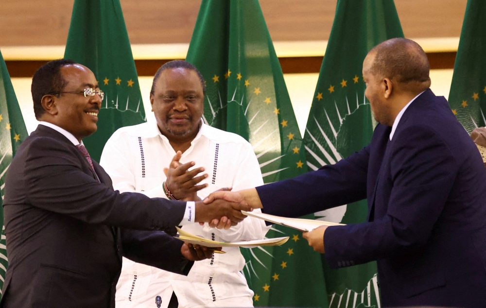 Former Kenyan President Uhuru Kenyatta applauds Ethiopian government representative Redwan Hussien and Tigray delegate Getachew Reda after signing the AU-led negotiations to resolve the conflict in northern Ethiopia, in Pretoria, South Africa, November 2, 2022. (REUTERS/Siphiwe Sibeko)