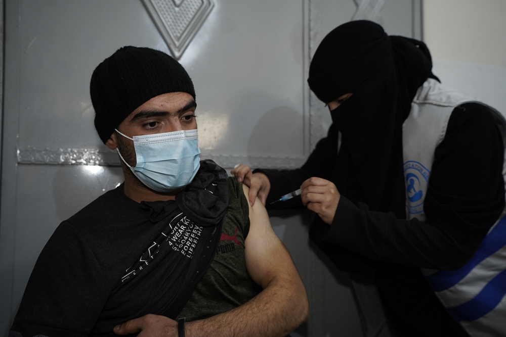 A beneficiary is receiving a shot under the WHO’s COVID-19 vaccination campaign in northern Syria.
