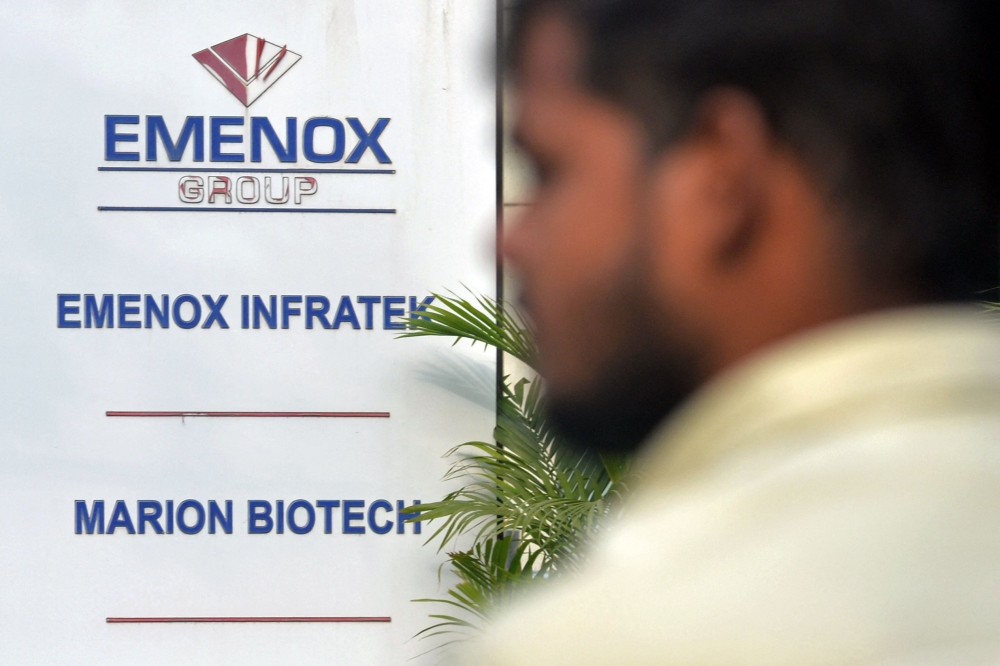 A man walks past the office entrance of Marion Biotech, a pharmaceutical company in Noida on the outskirts of New Delhi on December 29, 2022. (AFP)