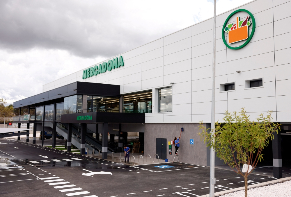 Workers clean the facade and entrance of a new Mercadona supermarket, a day before it opens to customers, in Ronda, southern Spain, April 27, 2022. REUTERS/Jon Nazca/File Photo