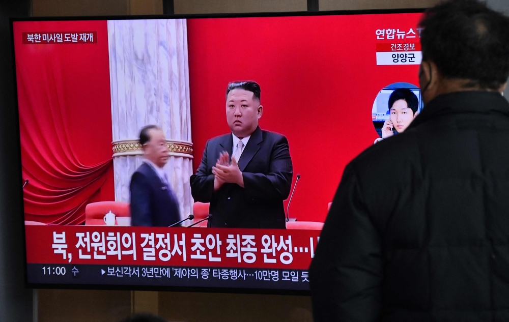 A man watches a television screen showing a news broadcast with file footage of North Korean leader Kim Jong Un, at a railway station in Seoul on December 31, 2022 after North Korea fired three short-range ballistic missiles according to South Korea's military. (Photo by Jung Yeon-je / AFP)