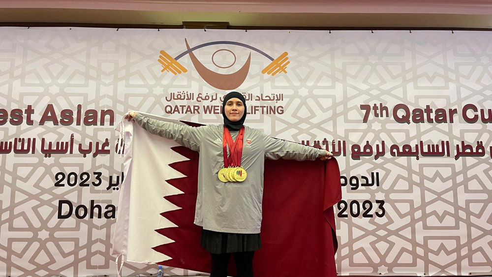 A Qatari weightlifter poses with her medals.