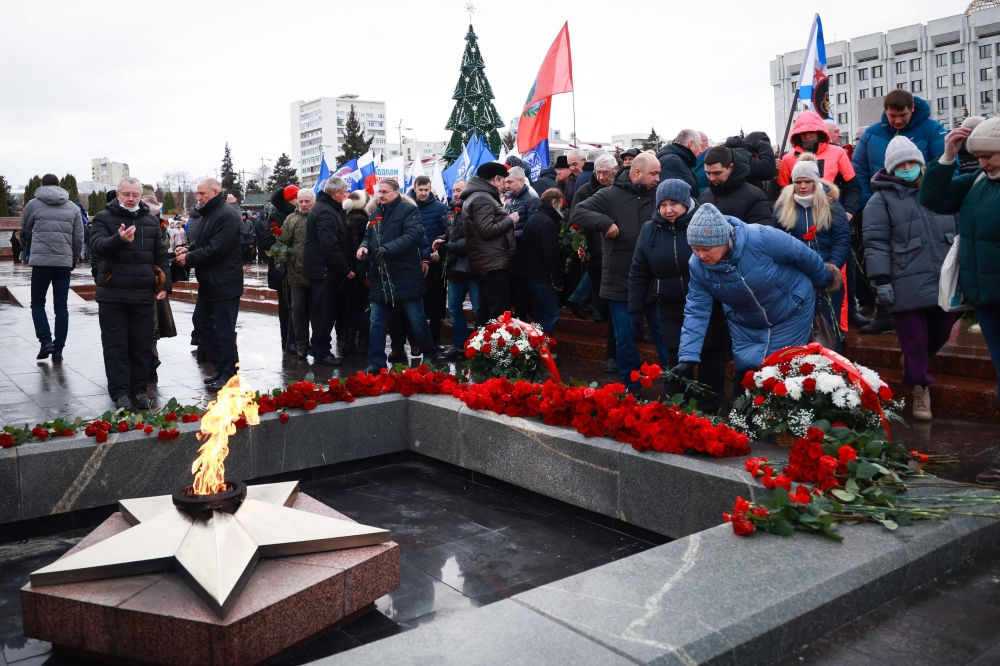 Mourners gather to lay flowers in memory of more than 60 Russian soldiers that Russia says were killed in a Ukrainian strike on Russian-controlled territory, in Samara, on January 3, 2023.  (Photo by Arden Arkman / AFP)