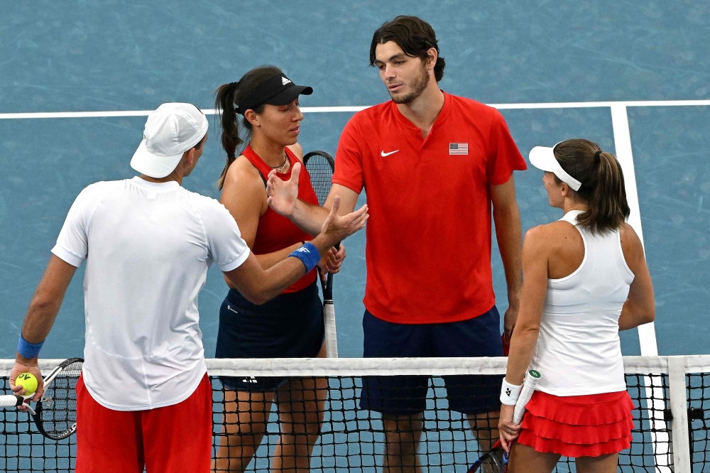 Taylor Fritz (second right) and Jessica Pegula (second left) of the US shake hands with Poland's Alicja Rosolska and Lukasz Kubot (left) after winning in the mixed doubles semi-final match at the United Cup tennis tournament in Sydney on January 7, 2023. (Photo by Saeed KHAN / AFP)