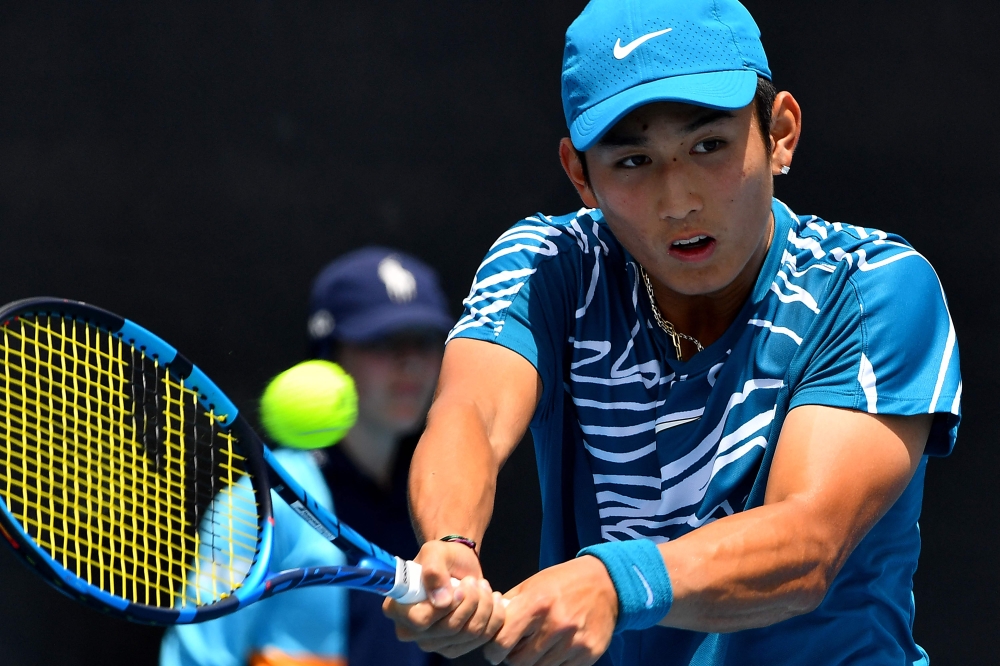 China's Shang Juncheng hits a return against Germany's Oscar Otte during their men's singles match on day one of the Australian Open tennis tournament in Melbourne on January 16, 2023. (Photo by Paul Crock / AFP)