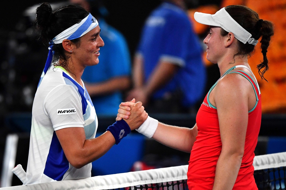 Tunisia's Ons Jabeur (left) shakes hands with Slovenia's Tamara Zidansek after their women's singles match on day two of the Australian Open tennis tournament in Melbourne on January 17, 2023. (Photo by Paul CROCK / AFP)