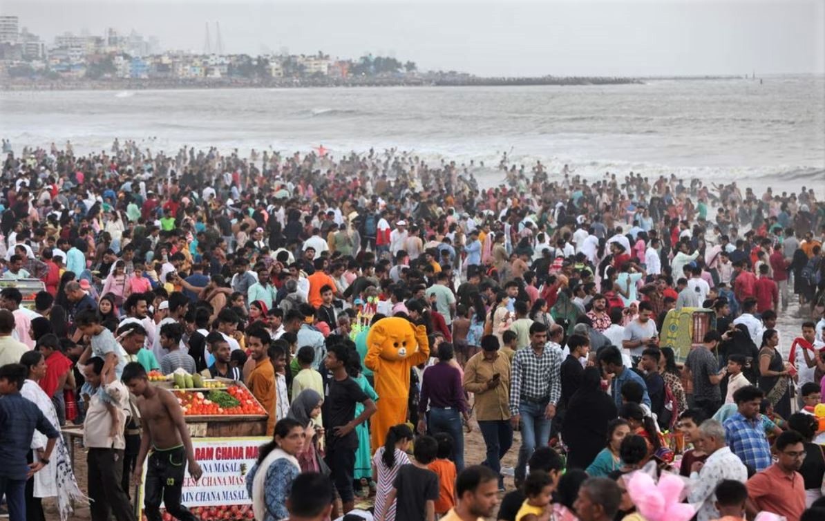 A man dressed as a teddy bear entertains people at a crowded beach in Mumbai, India, June 12, 2022. (REUTERS/Francis Mascarenhas)