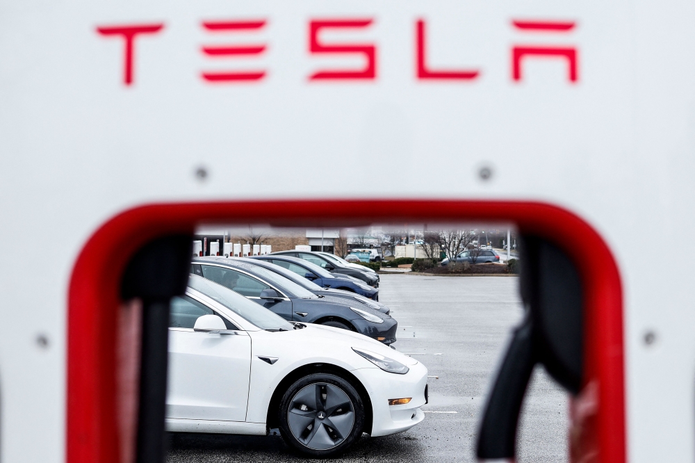 Tesla owners use charging stations in a parking lot on January 17, 2023 in Springfield, Virginia. The automaker decreased the prices of their Tesla's by 20 percent, a move seen as a reaction to competition in the global market for electric vehicles and rising inflation rates. Anna Moneymaker/Getty Images/AFP