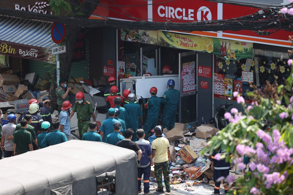 Rescue workers carry out equipment from a Circle-K convenience store after part of the building collapsed, killing a 15-year-old girl, in Ho Chi Minh City on January 18, 2023. Photo by Dat Tran / AFP