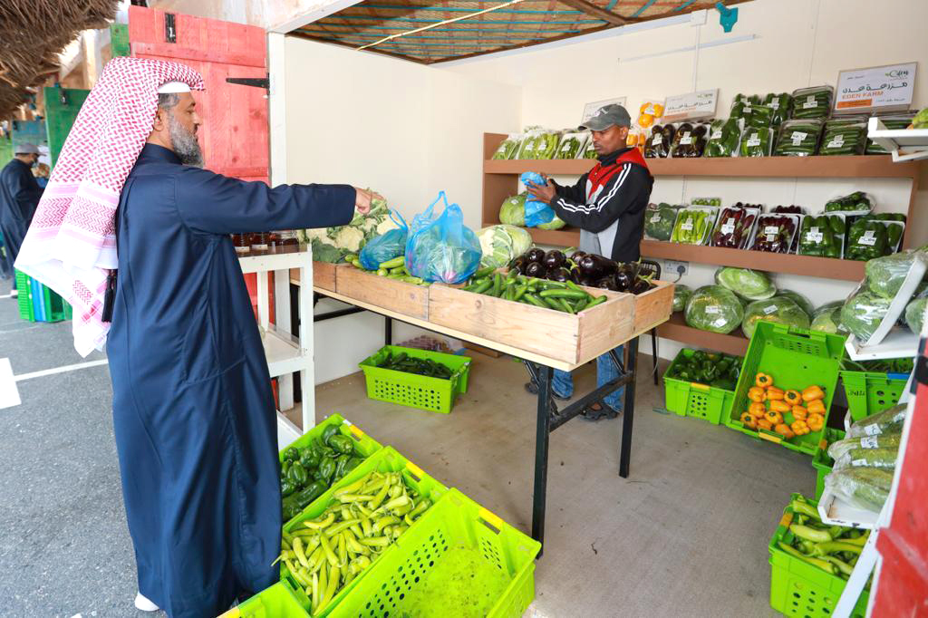 A customer buying vegetables at the Mahaseel Festival.