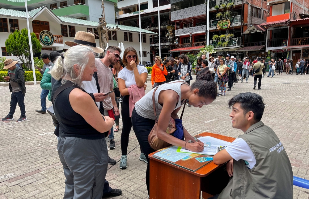 Tourists queue to signup a petition to the railroad company to be evacuated on a 