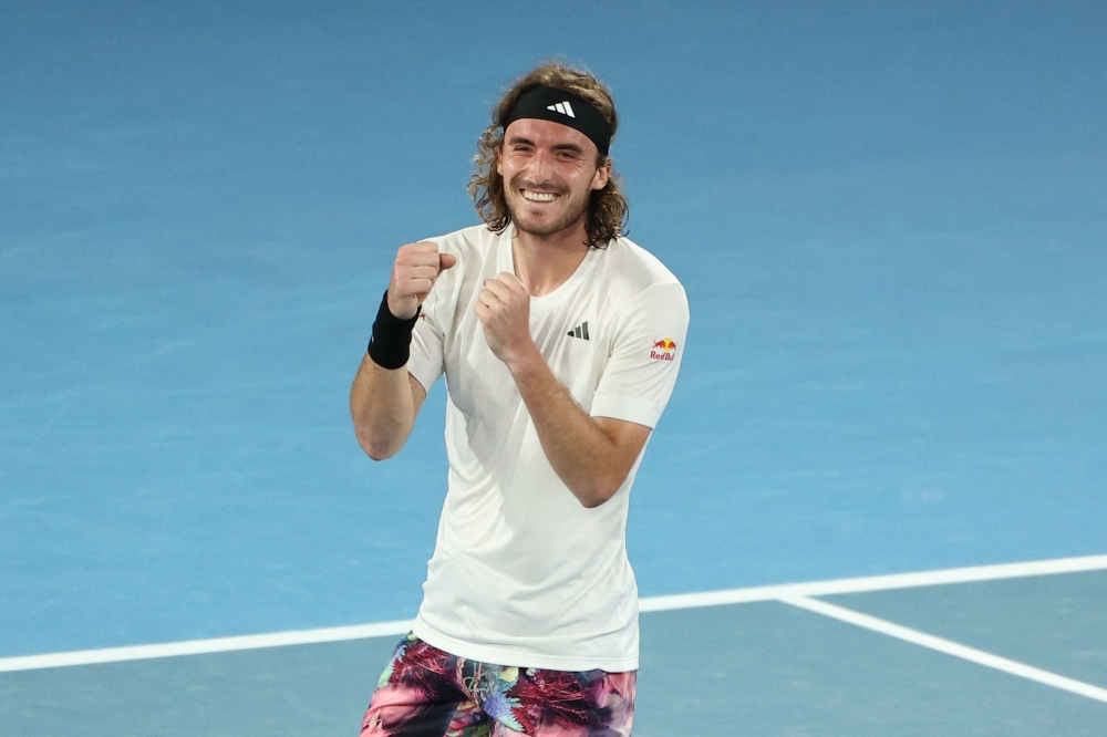 Greece's Stefanos Tsitsipas celebrates after victory against Italy's Jannik Sinner during their men's singles match on day seven of the Australian Open tennis tournament in Melbourne on January 22, 2023. (Photo by Martin KEEP / AFP) 