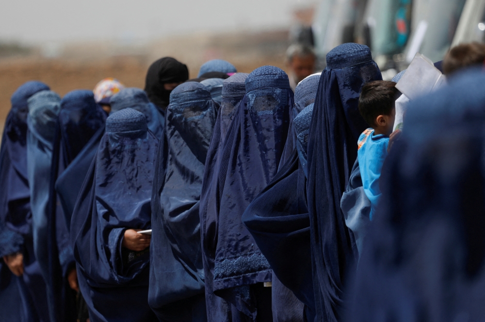 
File Photo: Displaced Afghan women stand waiting to receive cash aid for displaced people in Kabul, Afghanistan, July 28, 2022. (REUTERS/Ali Khara)
