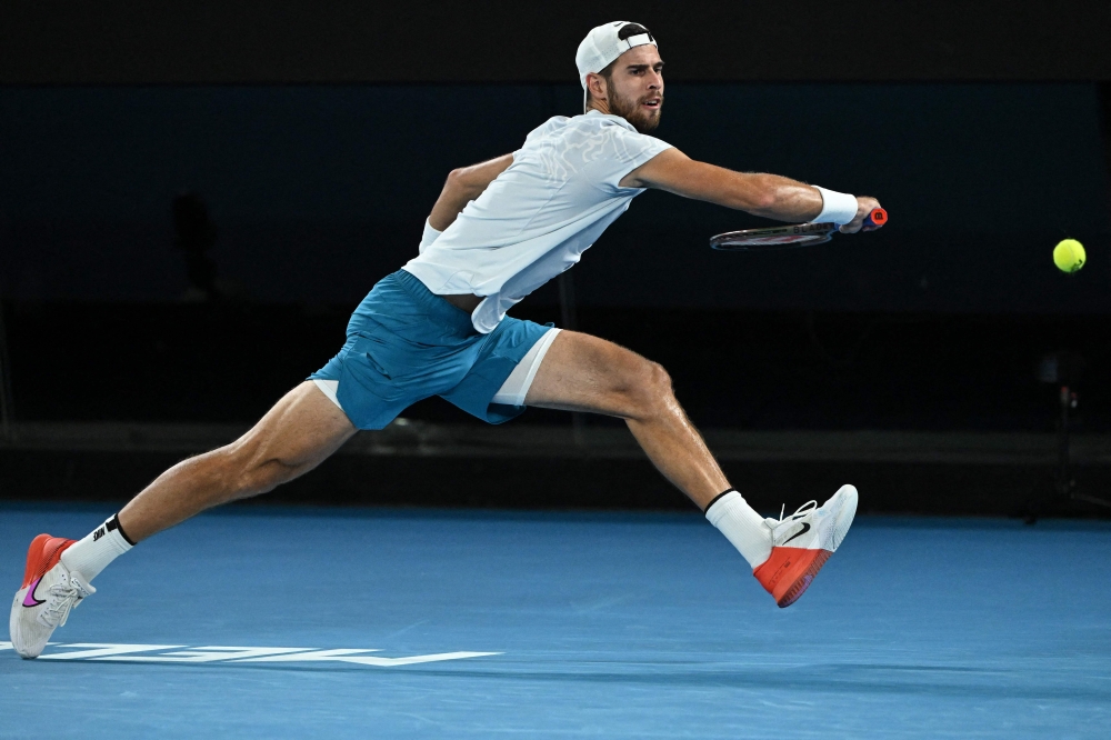 Russia's Karen Khachanov hits a return against USA's Sebastian Korda during their men's singles quarter-final match on day nine of the Australian Open tennis tournament in Melbourne on January 24, 2023. (Photo by WILLIAM WEST / AFP)