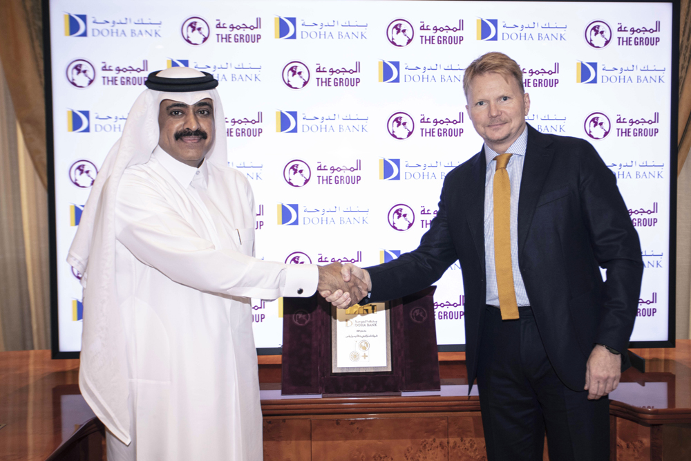 Doha Bank and the Group Securities Company  officials shake hands during launch event. 