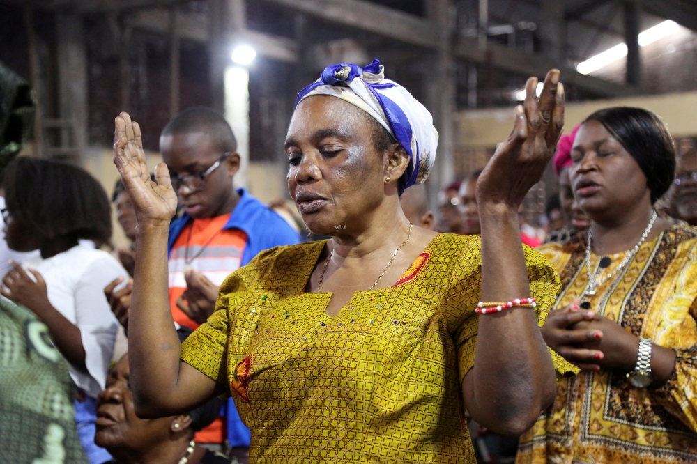 A faithful of the parish of St Charles prays as she attends the morning mass officiated by Abbey Victor Ntambwe, during which he sensitizes people to participate in the electoral process, in Kinshasa, Democratic Republic of Congo, on January 22, 2023. File Photo / Reuters