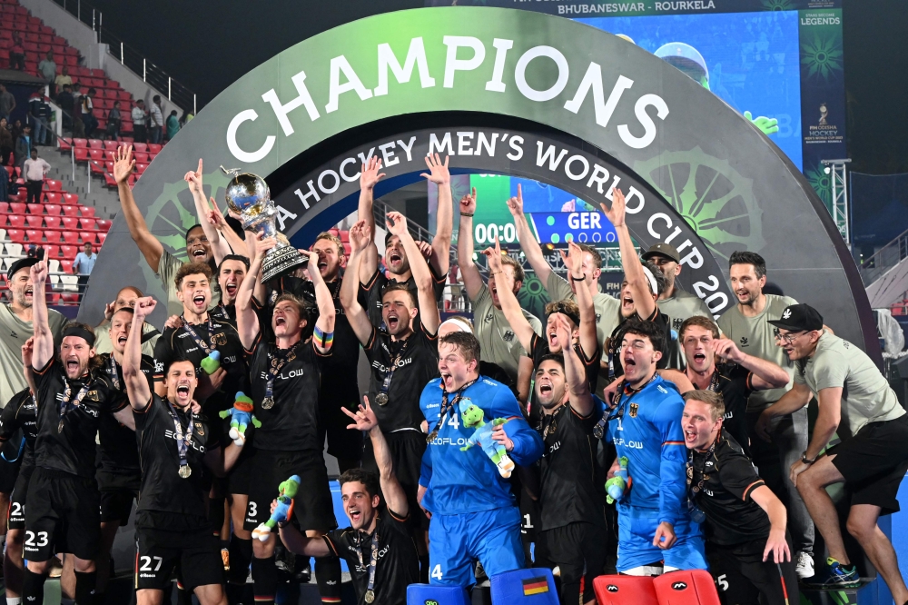 Germany's players pose with the trophy after winning the FIH men's hockey World Cup 2023 final match against Belgium at the Kalinga Stadium in Bhubaneswar, India, on January 29, 2023. (Photo by DIBYANGSHU SARKAR / AFP)