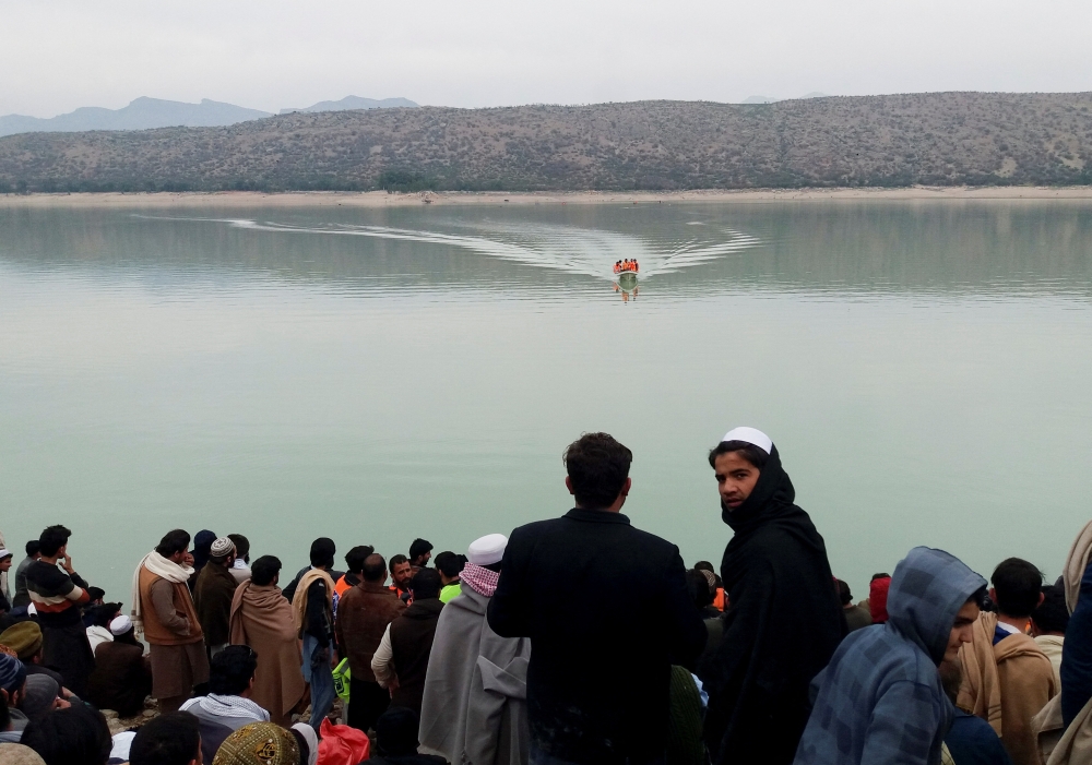 People gather as rescue workers search for the victims, after a boat carrying students capsized in Tanda lake in Kohat, Pakistan, January 29, 2023. (REUTERS)