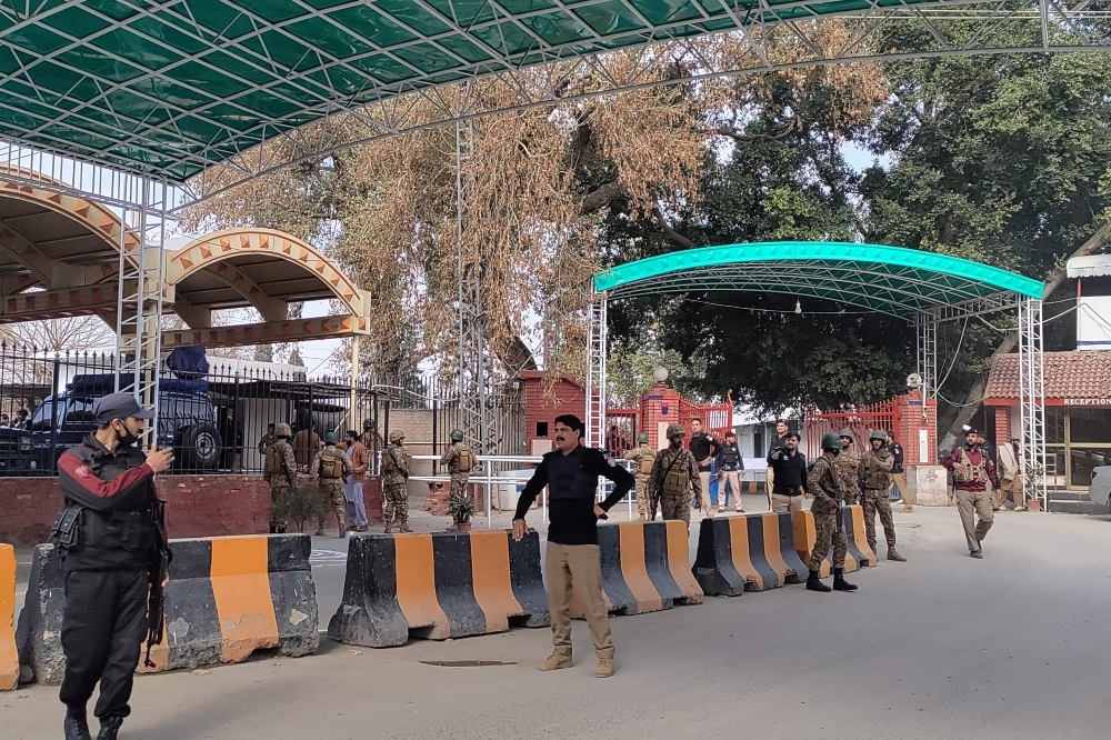Security personnel stand guard outside the police headquarters after a blast in Peshawar on January 30, 2023. (Photo by Abdul Majeed / AFP)