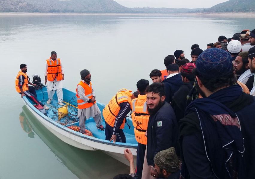 People and rescue workers gather after a boat carrying religious school students capsized in Tanda lake in Kohat, Pakistan, January 29, 2023. (REUTERS)
