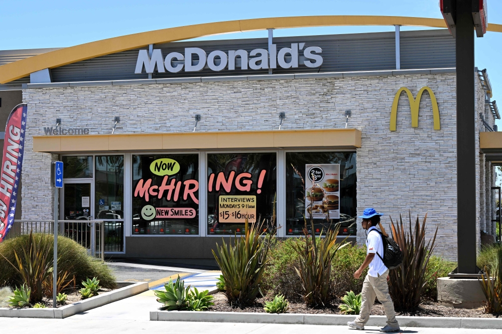 In this file photo taken on July 8, 2022, A man walks past a 