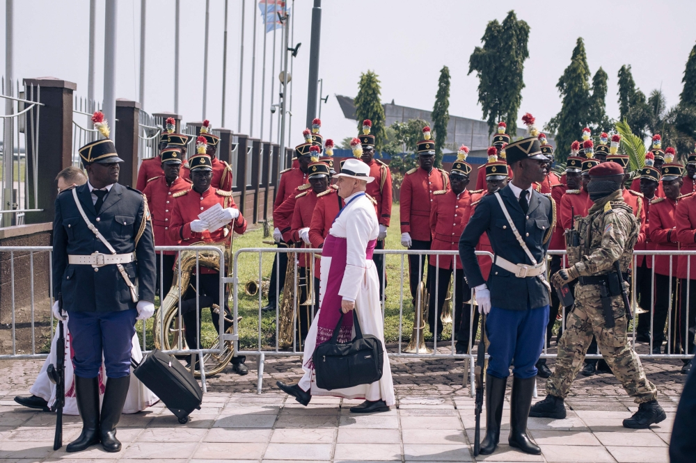 A member (C) of Pope Francis' delegation makes his way to the plane for departure from the Democratic Republic of Congo (DRC), at the N'djili International Airport in Kinshasa, DRC, on February 3, 2023.