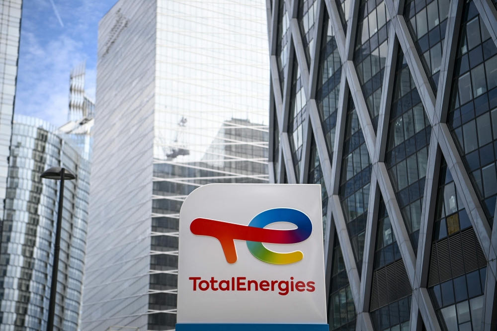 In this file photo taken on May 28, 2021 a photograph shows the new TotalEnergies logo during its unveling ceremony, at a charging station in La Defense on the outskirts of Paris. - France's TotalEnergies said Wednesday that high oil and gas prices bolstered its net profit to a record $20.5 billion in 2022. (Photo by Christophe ARCHAMBAULT / AFP)