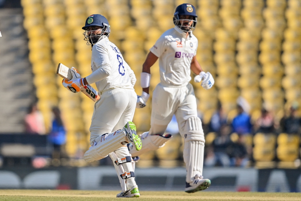 India's Ravindra Jadeja (L) with teammate Axar Patel run between the wickets during the third day of the first Test cricket match between India and Australia on February 11, 2023. (Photo by Indranil Mukherjee / AFP)