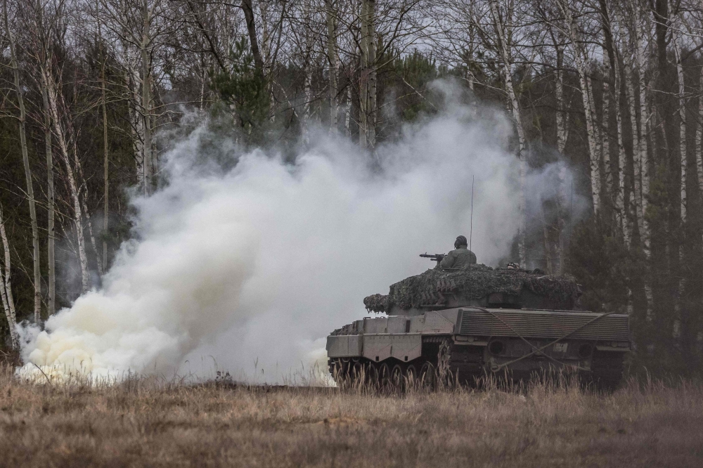 Polish and Ukrainian soldiers train on a Leopard 2 tank at the Swietoszow military base in western Poland on February 13, 2023. (Photo by Wojtek Radwanski / AFP)